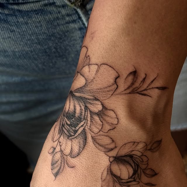 Tatuaggio botanico: fiori e foglie sul fianco