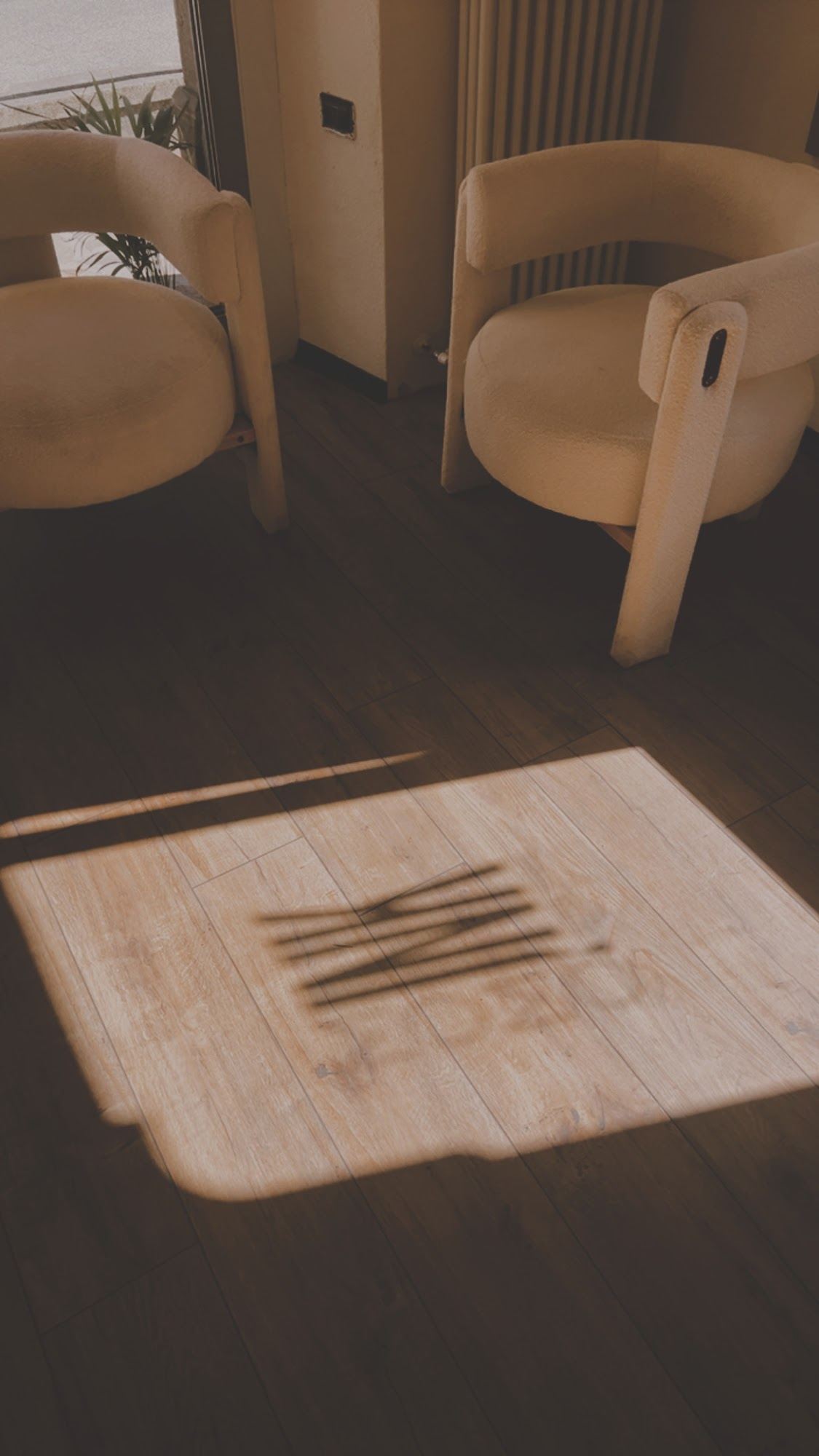 Lo studio Momo Ink: le poltrone bianche e l'ombra del logo sul parquet